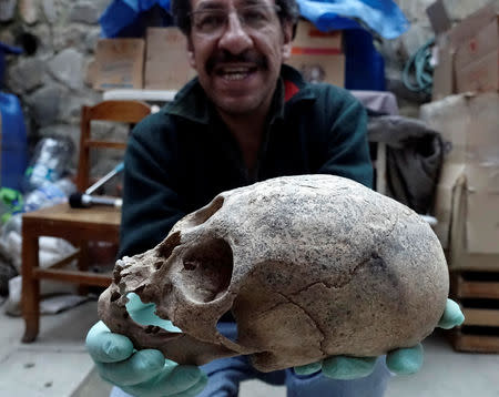 Archeologist Jedu Sagarnaga holds a skull as part of an archeological finding, dated approximately 500 years ago, in Mazo Cruz, near Viacha, Bolivia, November 12, 2018. Picture taken November 12, 2018.REUTERS/David Mercado