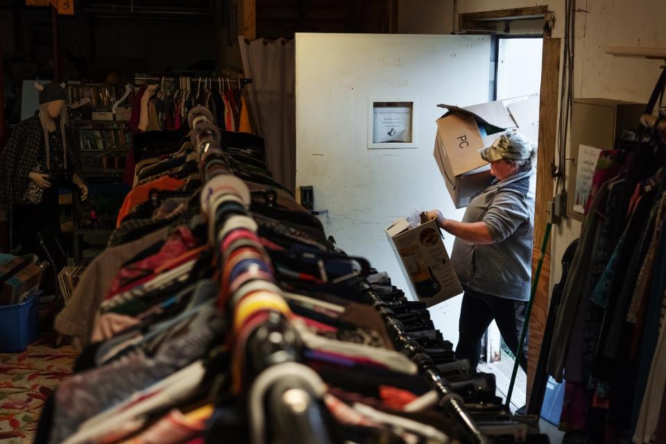 Shannon's Home Cooking owner Shannon Greathouse hauls in boxes of used items to put out for sale at Model Tots, a children's resale store, in Gwinn on Wednesday, Oct. 20, 2021.