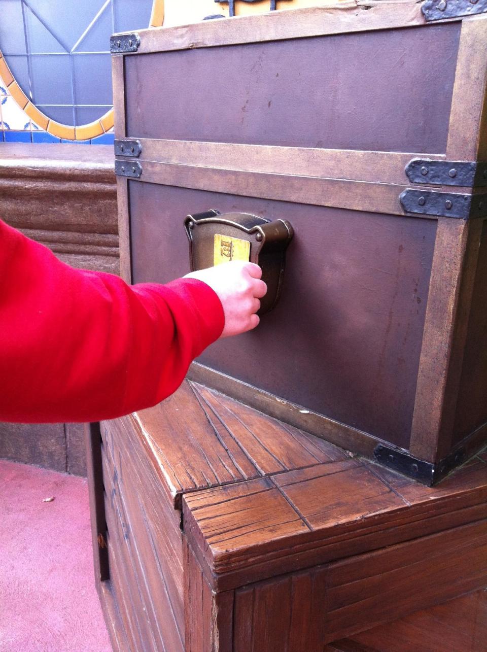 In this Feb. 15, 2013 photo, a Walt Disney World guest swipes his key card while playing the "Sorcerers of the Magic Kingdom" game at the Magic Kingdom theme park in Lake Buena Vista, Fla. The "Sorcerers" game and others like it represent a recent push by Disney World to provide its guests with attractions that allow them to interact with their favorite characters. (AP Photo/Mike Householder)