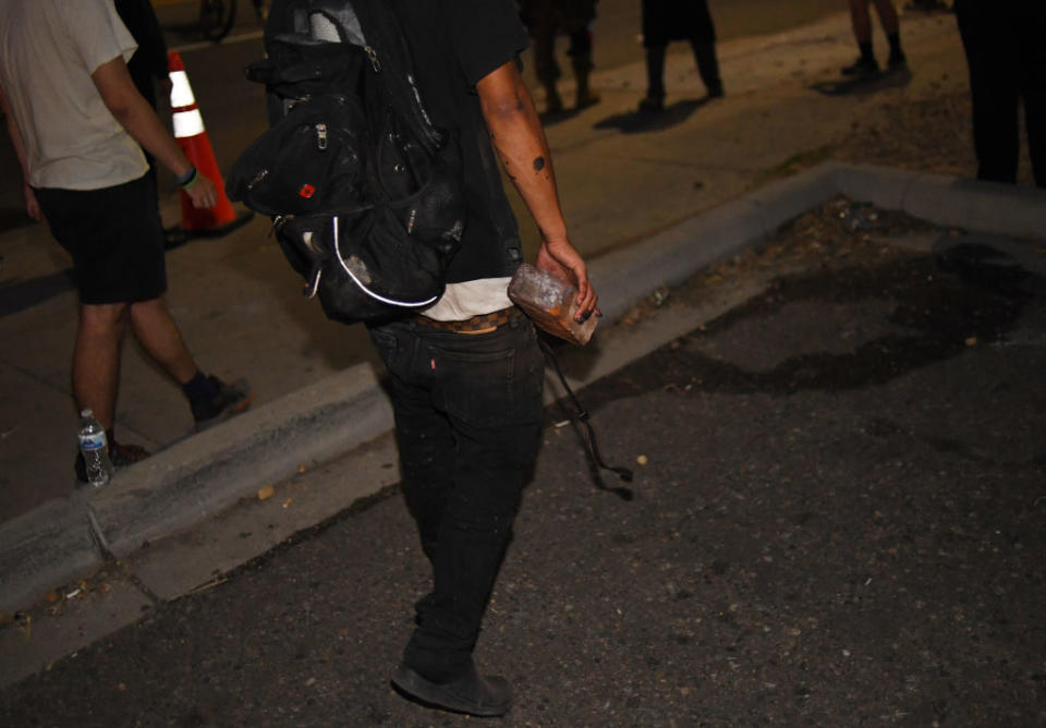 A man hold a brick in his hand during a protest in Denver. Source: Getty