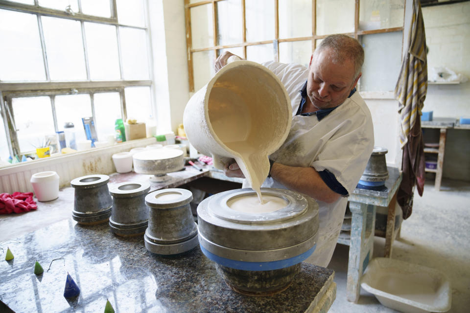 Mouldmaker Melvyn Grundy pours plaster into a mould, at the Duchess China 1888 factory, in Stoke-on-Trent, England, Thursday, March 30, 2023. With just five weeks to go until King Charles III’s coronation, an historic pottery is busy producing “God Save The King” commemorative china plates and mugs to mark the occasion. (AP Photo/Jon Super)