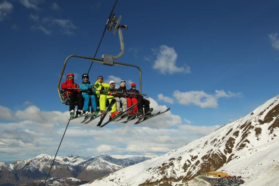 Skiiers ride a chairlift at Treble Cone ski resort in Wanaka, New Zealand.