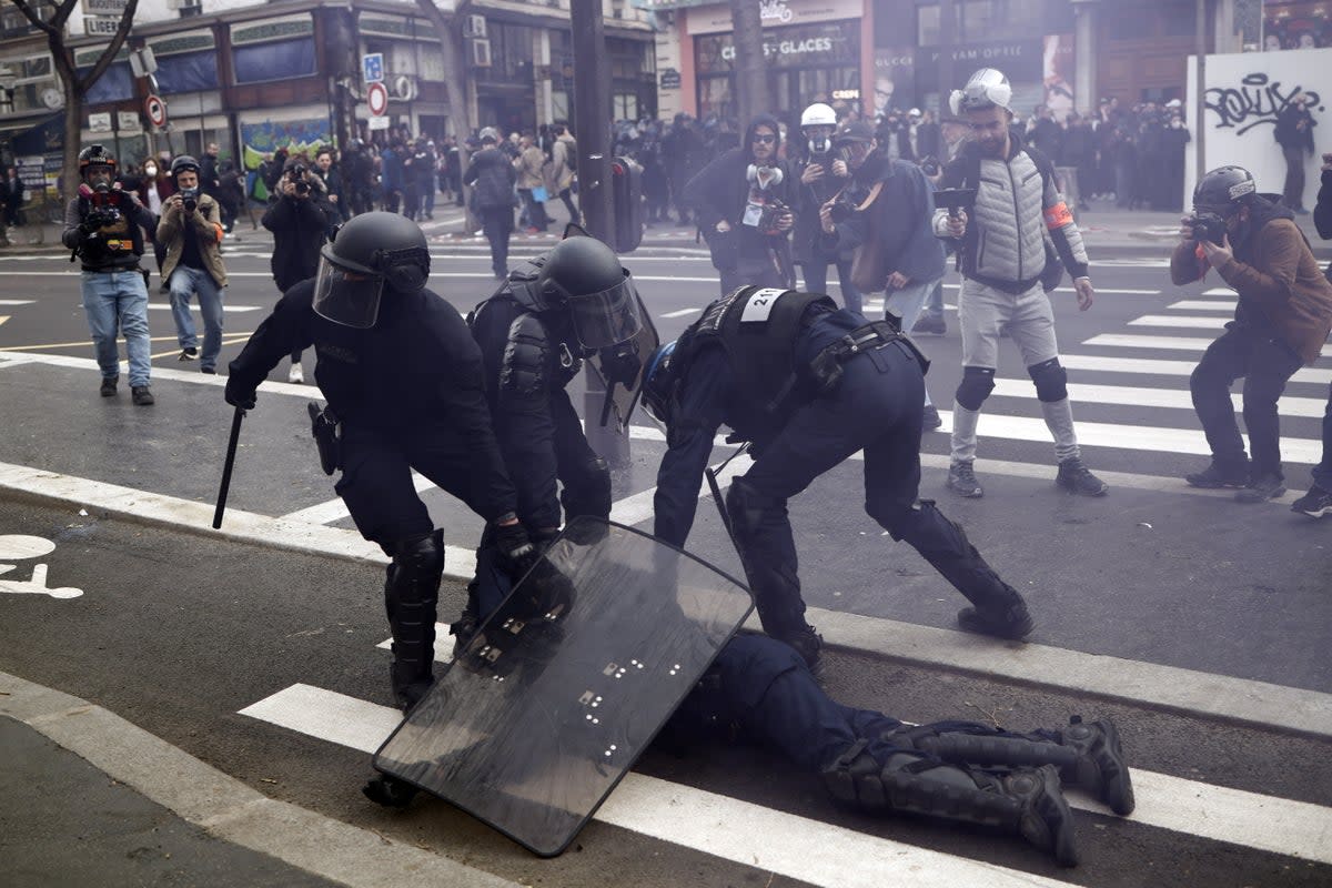 French police officers protect a colleague injured during clashes with protesters (EPA)