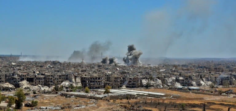 A picture taken during a government guided tour shows smoke rising from buildings in Yarmuk, a Palestinian refugee camp on the edge of the capital, during regime shelling targeting Islamic State (IS) group positions on April 24, 2018