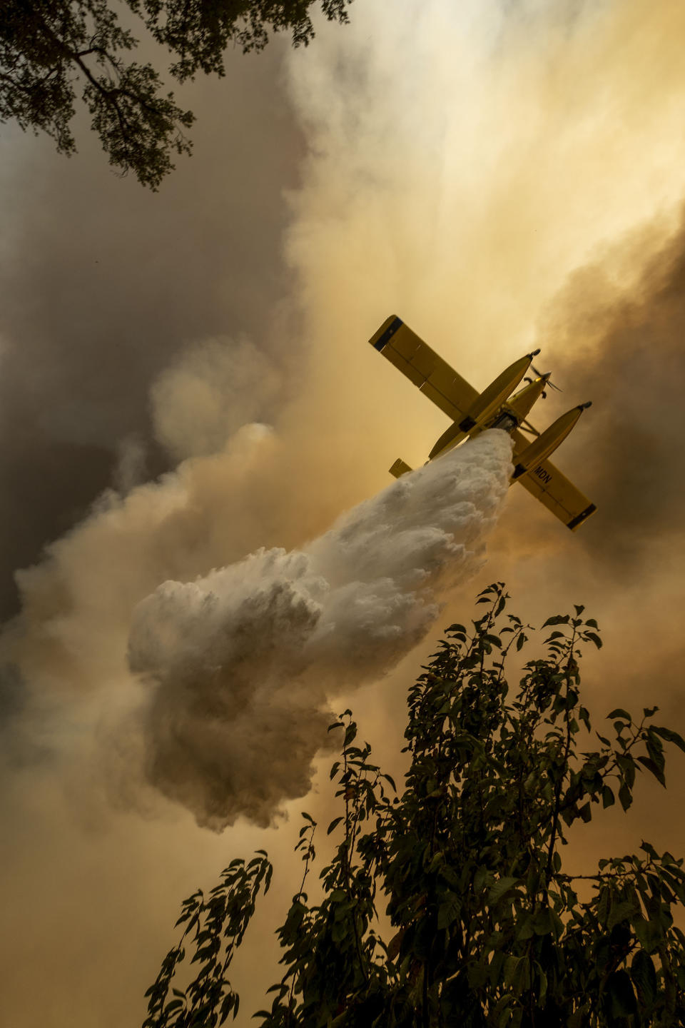 An airplane operates over a fire at the village of Chaveira, near Macao, in central Portugal on Monday, July 22, 2019. More than 1,000 firefighters are battling a major wildfire amid scorching temperatures in Portugal, where forest blazes wreak destruction every summer. About 90% of the fire area in the Castelo Branco district, 200 kilometers (about 125 miles) northeast of the capital Lisbon, has been brought under control during cooler overnight temperatures, according to a local Civil Protection Agency commander. (AP Photo/Sergio Azenha)