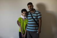 Hoda Kinno, 11, and her uncle Mustafa Kinno, pose for a photograph at a temporary apartment in the coastal town of Jiyeh, south of Beirut, Lebanon, Tuesday, Sept. 15, 2020. The Kinno family from Syria's Aleppo region was devastated in the wake of the Aug. 4 explosion at the Beirut port -- Hoda suffered a broken neck and other injuries and her sister Sedra, 15, died in the explosion. (AP Photo/Hassan Ammar)