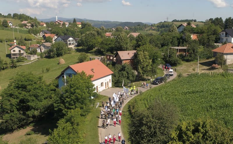 People walk through a forest near the village of Snagovo