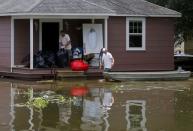 Devin Duplessis (C) and a friend remove furniture from his flooded home in Sorrento, Louisiana. REUTERS/Jonathan Bachman