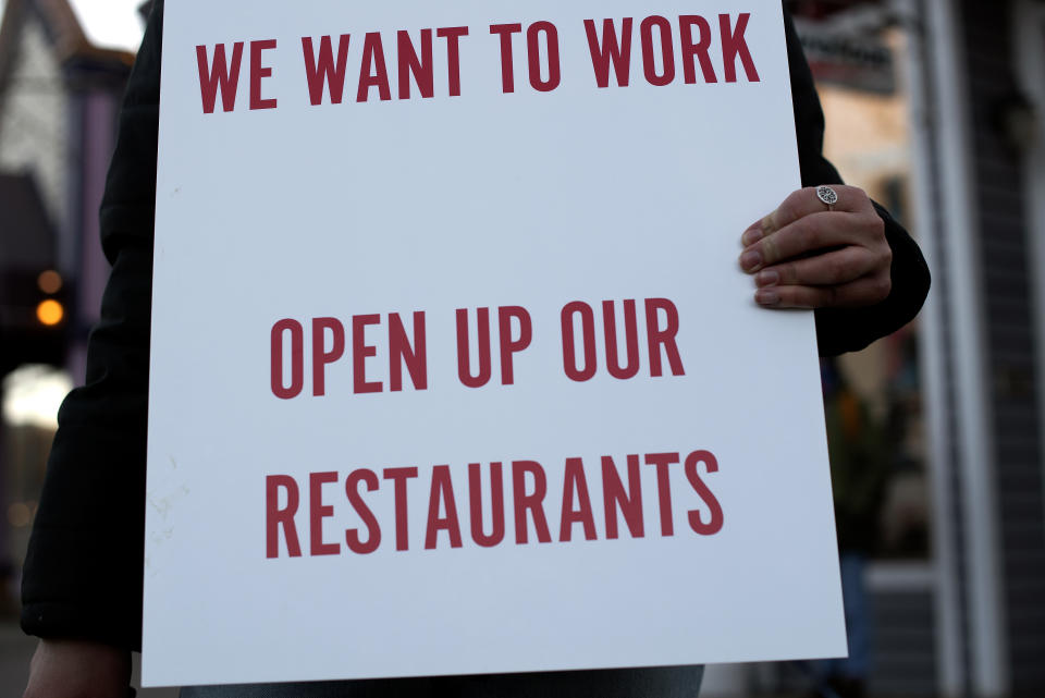 A Summit County service industry worker holds a sign while protesting the prohibition of in-person dining at restaurants Monday, Nov. 23, 2020 in Breckenridge, Colo. (Jason Connolly/Summit Daily News via AP)