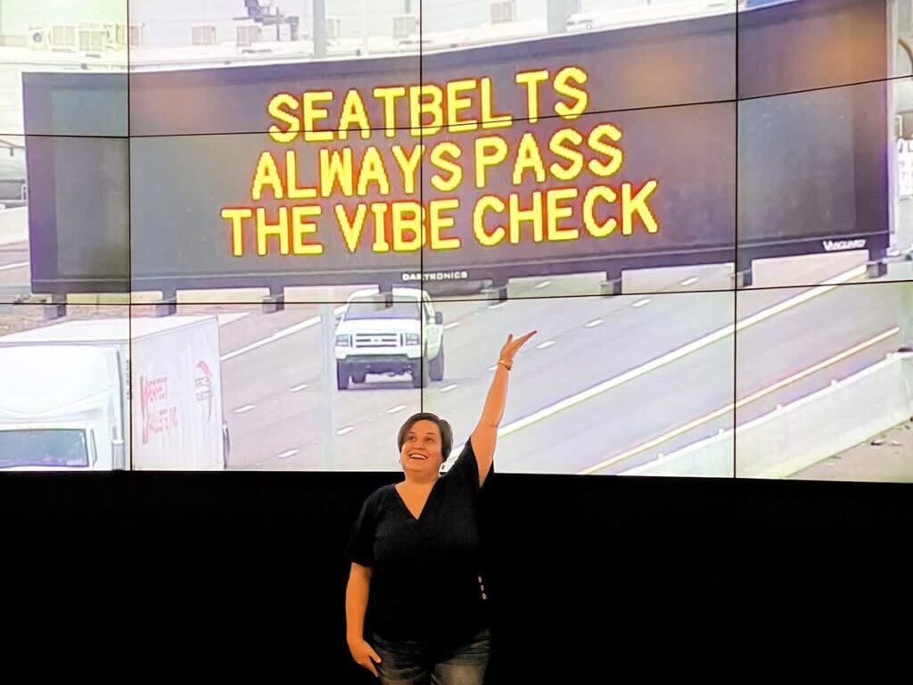 Elise Riker, a marketing professor at Arizona State University, shows off her winning contest entry for a state highway safety message displayed last fall. States are using more creative message to get attention, but federal authorities have warned that confusing messages could actually increase crashes. Courtesy of the Arizona Department of Transportation