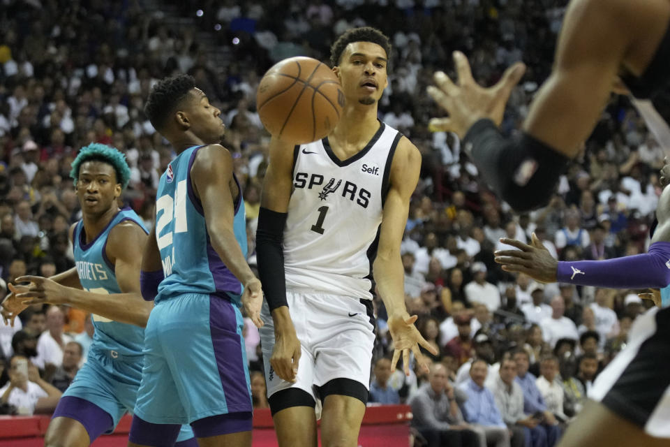 San Antonio Spurs' Victor Wembanyama passes around Charlotte Hornets' Brandon Miller during the first half of an NBA summer league basketball game Friday, July 7, 2023, in Las Vegas. (AP Photo/John Locher)