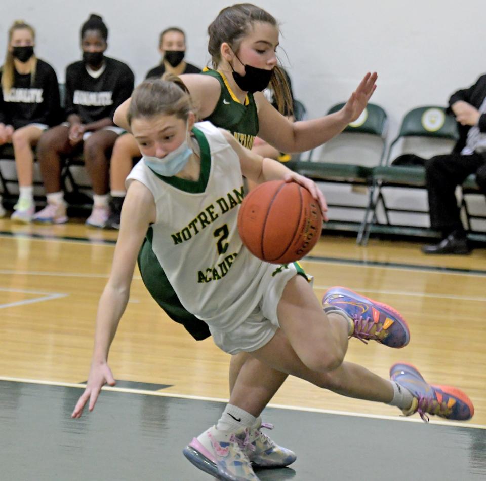 Notre Dame's Gracyn Barnes is tripped up on her drive to the hoop by Tantasqua's Maya Gidoupolos.