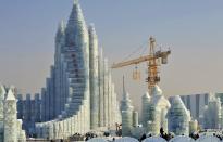 Workers and a crane are seen next to a newly-built ice sculpture of a castle ahead of the 30th Harbin Ice and Snow Festival, in Harbin, Heilongjiang province December 27, 2013. According to the festival organizers, nearly 10,000 workers were employed to build the ice and snow sculptures, which require about 180,000 square metres of ice and 150,000 square metres of snow. The festival kicks off on January 5, 2014. REUTERS/Sheng Li (CHINA - Tags: ENVIRONMENT SOCIETY BUSINESS EMPLOYMENT TPX IMAGES OF THE DAY TRAVEL) CHINA OUT. NO COMMERCIAL OR EDITORIAL SALES IN CHINA