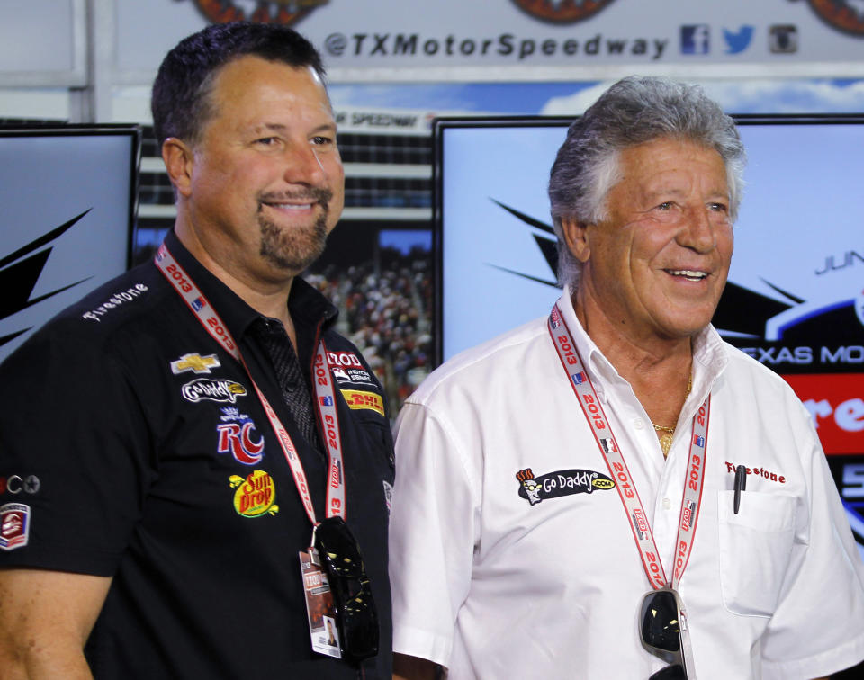 FILE - In this June 7, 2013, photo, Michael Andretti, left, and his father, Mario Andretti, pose for a photo following a news conference at Texas Motor Speedway in Fort Worth, Texas, June 7, 2013. The FIA on Monday, Oct. 2, 2023, said Michael Andretti meets all required criteria to field a future Formula One team. Monday's announcement was a first — but important — step in Andretti's three-year quest to return one of racing's most storied names to the pinnacle of motorsports. Mario Andretti won the 1978 F1 championship and Michael, his son, ran 13 races during the 1993 season. The father and son are among the most successful racers in American open wheel history and rank third and fourth on IndyCar's all-time win list. (AP Photo/Tim Sharp, File)