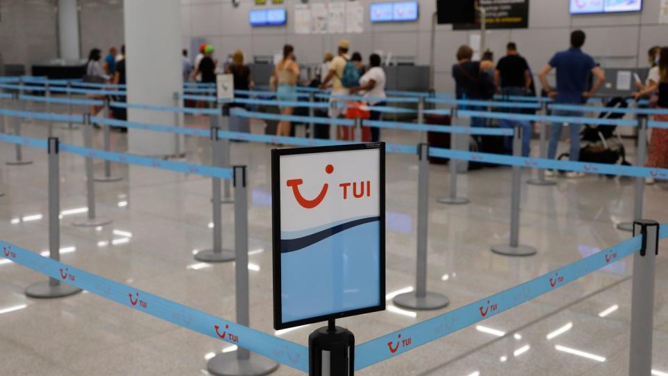 Passagiere stehen am Flughafen Palma am Abfertigungsschalter von Tui.