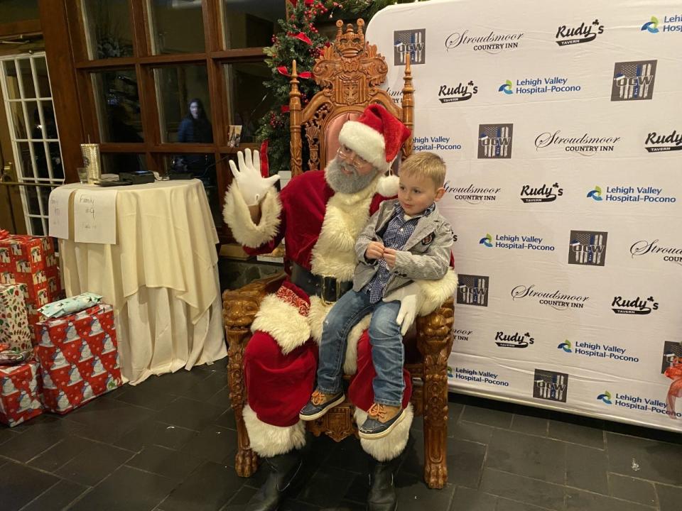 A little boy gets his photo with Santa during the Olsen Christmas Wish event at Stroudsmoor Country Inn on Dec. 21. Over 200 children received presents from the organization, which raises funds to help provide Christmas gifts to families in need, at the special event.