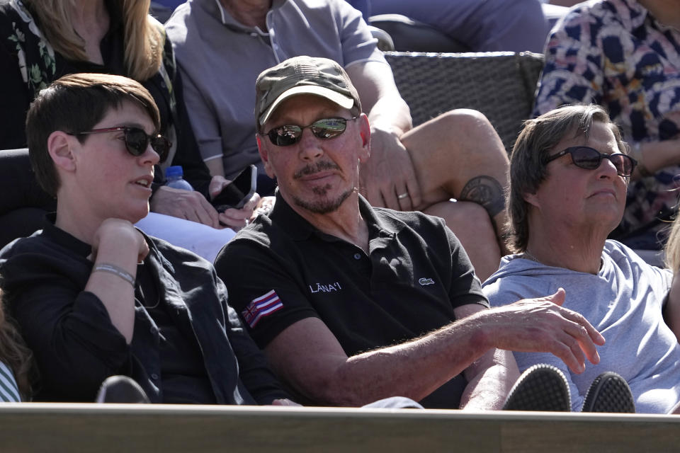 File - Oracle cofounder Larry Ellison, middle, watches a match at the BNP Paribas Open tennis tournament on March 18, 2023, in Indian Wells, Calif. A recent report from anti-poverty organization Oxfam highlighted how the fortunes of the world's five richest people — Tesla CEO Elon Musk, Amazon founder Jeff Bezos, Ellison, Bernard Arnault of luxury company LVMH, and investment guru Warren Buffett — have more than doubled since 2020. (AP Photo/Mark J. Terrill, File)