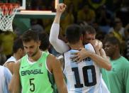 2016 Rio Olympics - Basketball - Preliminary - Men's Preliminary Round Group B Argentina v Brazil - Carioca Arena 1 - Rio de Janeiro, Brazil - 13/08/2016. Carlos Delfino (ARG) of Argentina hugs Andres Nocioni (ARG) of Argentina as Raulzinho Neto (BRA) of Brazil walks away. REUTERS/Jim Young