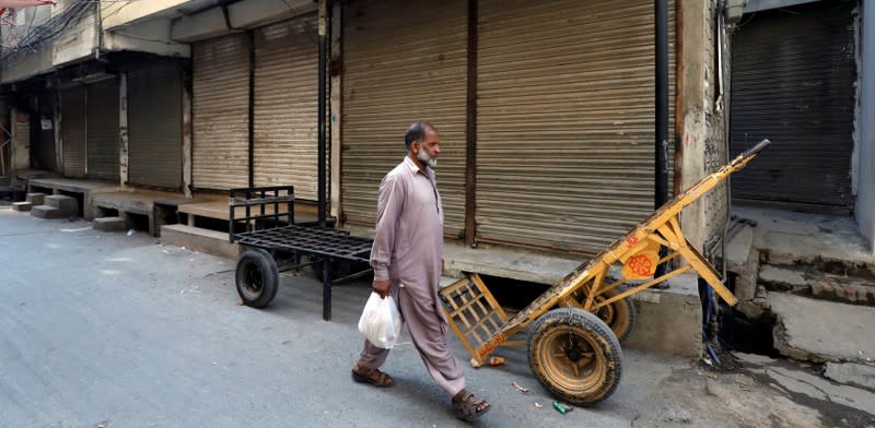 A man walks past closed shops during a country-wide lock down by the traders and business community against, what they say is imposition of taxes by the government in Rawalpindi