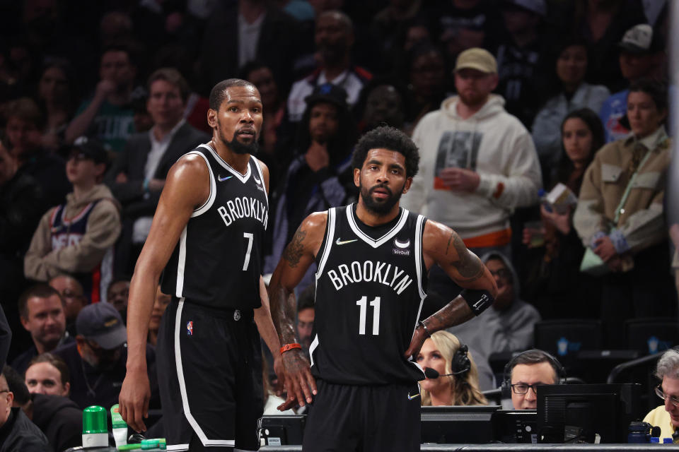 Kevin Durant and Kyrie Irving of the Brooklyn Nets look on in the final seconds of their 109-103 loss against the Boston Celtics during Game Three of the Eastern Conference First Round NBA Playoffs at Barclays Center on April 23, 2022 in New York City. 