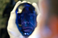 <p>Philanthropist Maurice Ostro is reflected in his Ostro stone, the largest known blue topaz stone, as he holds it for media at the Natural History Museum in London, Britain September 27, 2016. (Peter Nicholls/Reuters)</p>