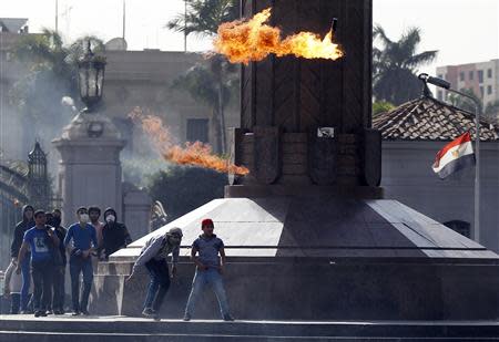 A masked student who is supporter of the Muslim Brotherhood and ousted President Mohamed Mursi throws a Molotov cocktail at riot police and residents during clashes outside Cairo University in this March 26, 2014 file photo. REUTERS/Amr Abdallah Dalsh/Files