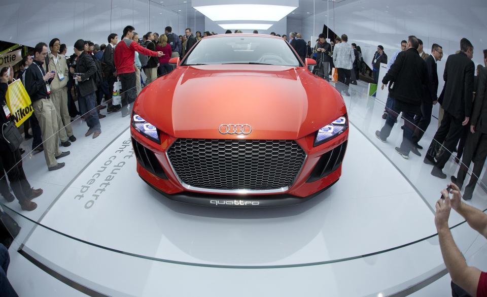 Trade show attendees gather around the Audi Sport quattro laserlight concept car at the International Consumer Electronics Show, Wednesday, Jan. 8, 2014, in Las Vegas. The car is outfitted with laser lights offering three times the illumination as LED lights. (AP Photo/Julie Jacobson)