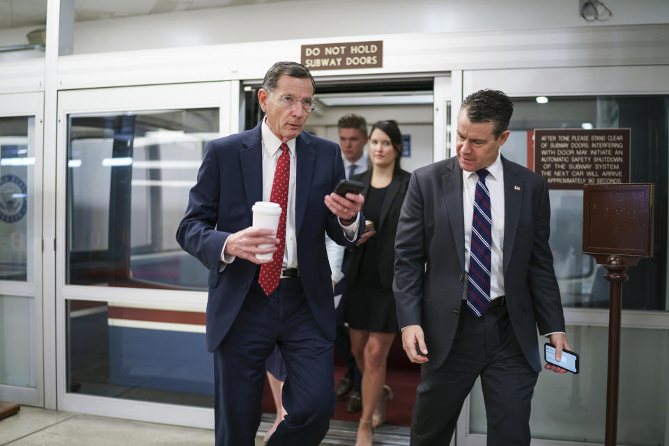 Sen. John Barrasso, R-Wyo., left, chairman of the Senate Republican Conference, and Sen. Todd Young, R-Ind., rush to the chamber for votes ahead of the approaching Memorial Day recess, at the Capitol in Washington, Thursday, May 27, 2021. Senate Republicans are ready to deploy the filibuster to block a commission on the Jan. 6 insurrection, shattering chances for a bipartisan probe of the deadly assault on the U.S. Capitol and reviving pressure to do away with the procedural tactic that critics say has lost its purpose. (AP Photo/J. Scott Applewhite)