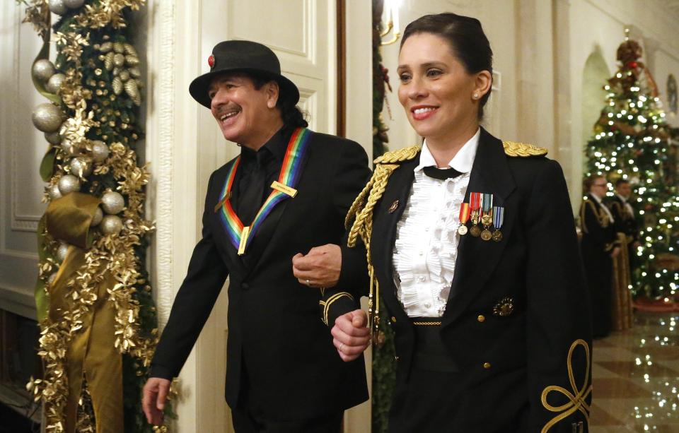 Musician Santana is escorted as he arrives with fellow Kennedy Center honorees for a reception at the White House in Washington