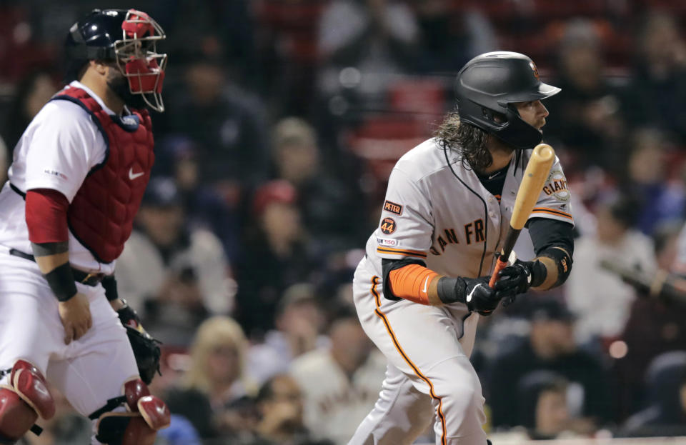 San Francisco Giants' Brandon Crawford, watches the flight of his go-ahead RBI double during the 13th inning of the team's baseball game against the Boston Red Sox at Fenway Park in Boston, Tuesday, Sept. 17, 2019. At left is Red Sox catcher Sandy Leon. (AP Photo/Charles Krupa)