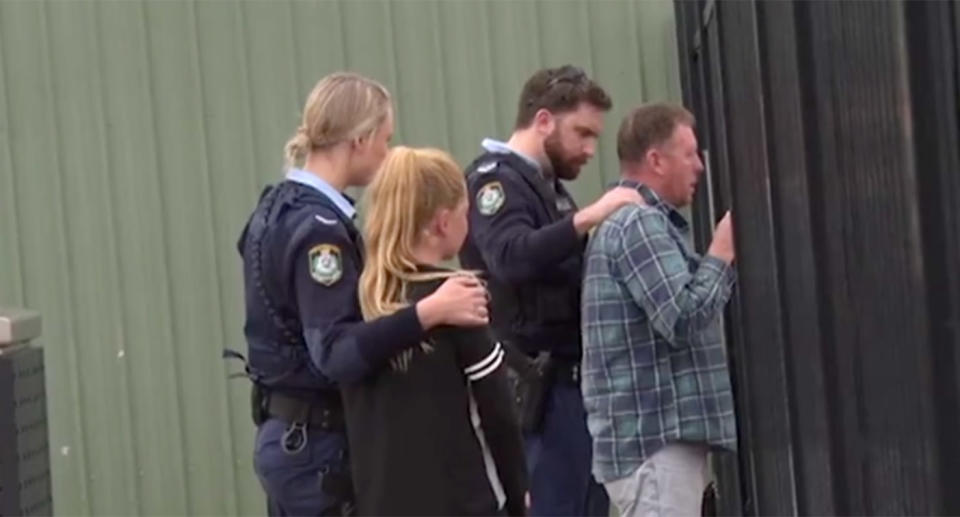 The boy's family is comforted by police officers at Bathurst Airport as they watch paramedics move him into the air ambulance