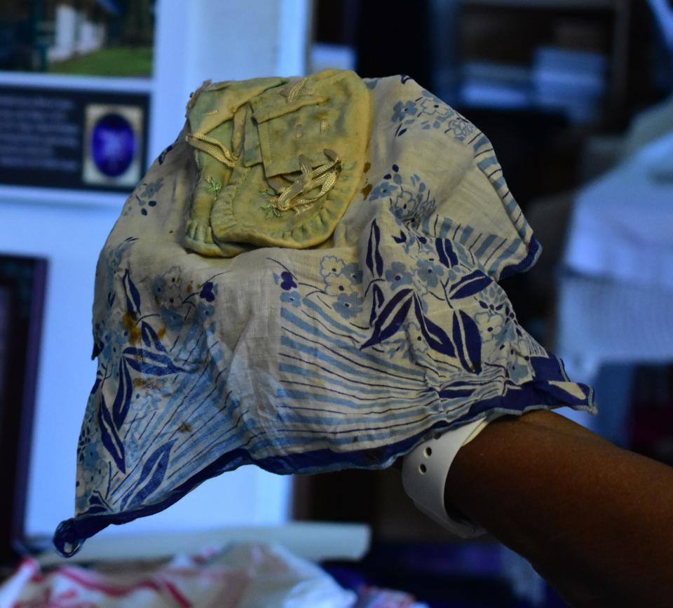 Lizzie Robinson Jenkins unwraps baby shoes that have been stored in a blue handkerchief for 100 years in Archer, Fla., last month. Although she was given the handkerchief many years ago, she only recently discovered that there were baby shoes inside.