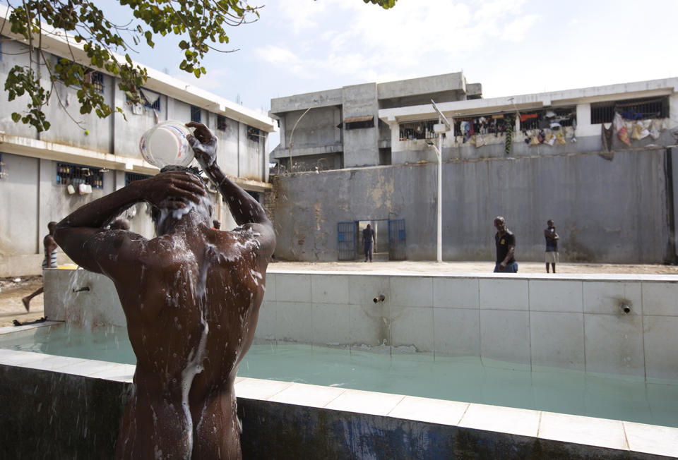 <p>A prisoner bathes during recreation time inside the National Penitentiary in downtown Port-au-Prince, Haiti, Feb. 13, 2017 . Inmates, some waiting up to eight years to see a judge, try to keep their sanity by maintaining a daily routine. (Photo: Dieu Nalio Chery/AP) </p>