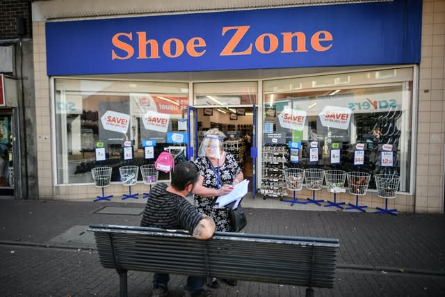 A woman wears a full face visor as she conducts a survey in the relatively empty shopping area of East Street, Bedminster, Bristol, where many shops and businesses are closed, some six months on from the evening of March 23 when Prime Minister Boris Johnson announced nationwide restrictions