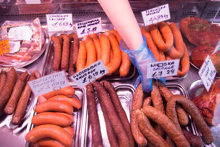 FILE PHOTO: A worker reaches for sausage at a Polish delicatessen in Grays in southern Britain December 11, 2015. REUTERS/Neil Hall/File Photo