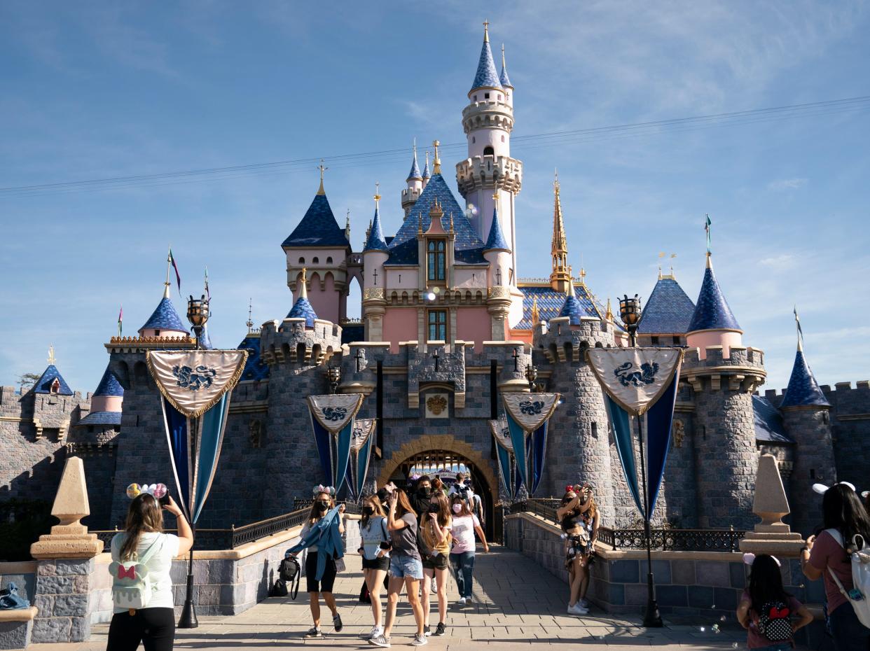 <p>Visitors exit The Sleeping Beauty Castle at Disneyland in Anaheim, California on 30 April 2021</p> (AP)