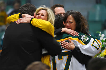 Mourners comfort each other as people attend a vigil at the Elgar Petersen Arena, home of the Humboldt Broncos, to honour the victims of a fatal bus accident in Humboldt, Saskatchewan, Canada April 8, 2018. Jonathan Hayward/Pool via REUTERS TPX IMAGES OF THE DAY