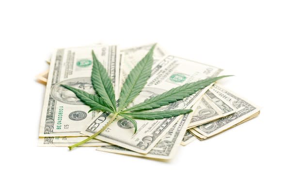 Marijuana leaf on top of U.S. cash