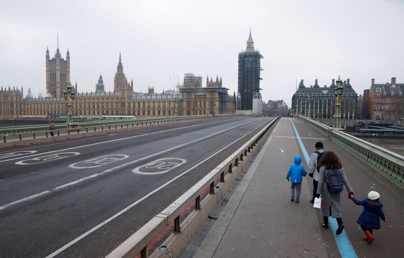 A family walks across deserted Westminster Bridge near the Houses of Parliament on New Year's Day amid the coronavirus disease (COVID-19) outbreak, in London