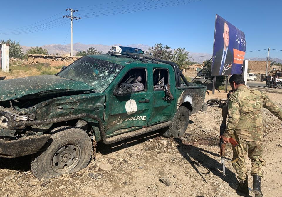 Afghan police inspect the site of a suicide attack, in Parwan province of Afghanistan, Tuesday, Sept. 17, 2019. The Taliban suicide bomber on a motorcycle targeted a campaign rally by President Ashraf Ghani in northern Afghanistan on Tuesday, killing at over 20 people and wounding over 30. Ghani was present at the venue but was unharmed, according to his campaign chief. (AP Photo/Rahmat Gul)