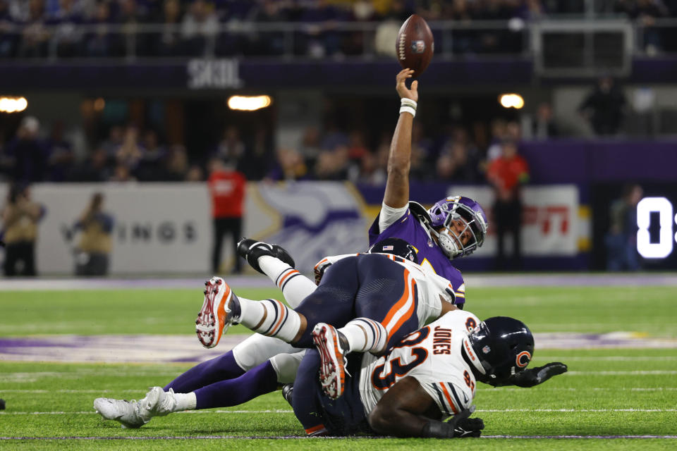 Minnesota Vikings quarterback Joshua Dobbs (15) throws a pass as he is tackled by Chicago Bears defensive tackle Justin Jones (93) during the first half of an NFL football game, Monday, Nov. 27, 2023, in Minneapolis. (AP Photo/Bruce Kluckhohn)