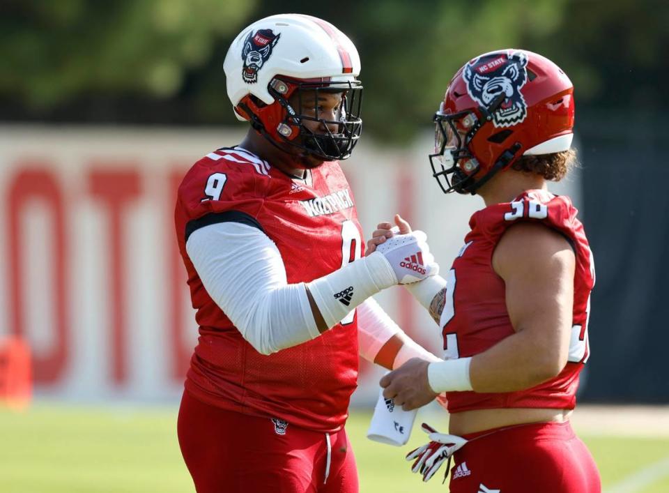 N.C. State defensive end Savion Jackson (9) greets Drake Thomas (32) at the start the Wolfpacks first practice of fall camp in Raleigh, N.C., Wednesday, August 3, 2022.