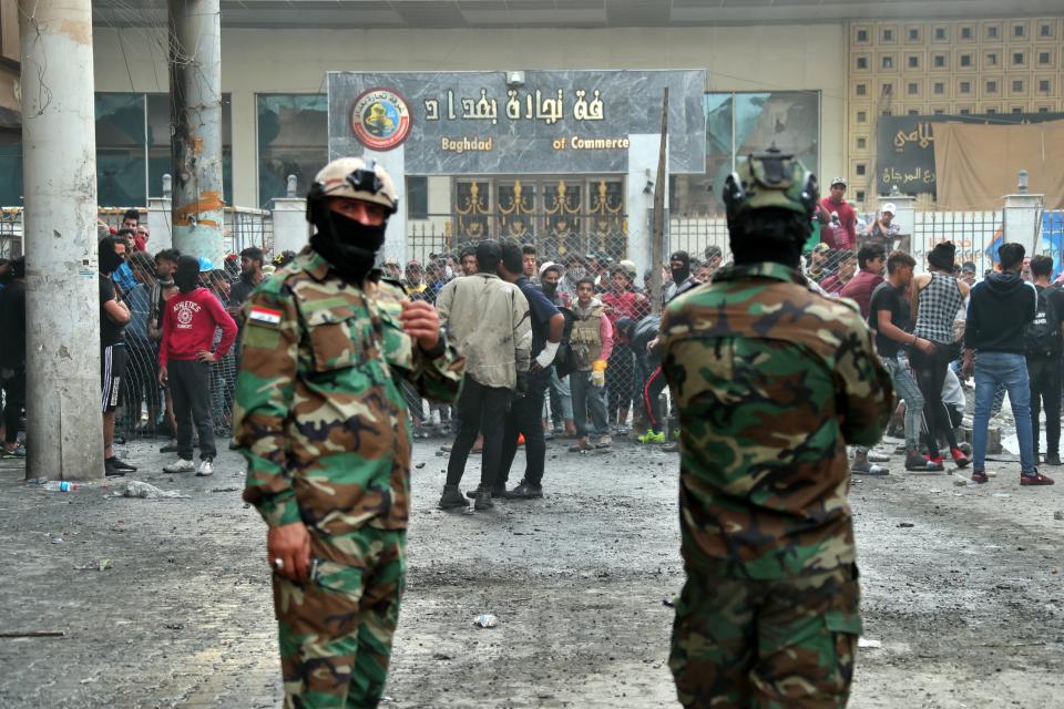 Anti-government protesters and security forces face-off on Rasheed Street, in Baghdad, Iraq, Sunday, Dec. 1, 2019. Iraq's parliament approved the resignation of Prime Minister Adel Abdul-Mahdi on Sunday, amid ongoing violence and anti-government demonstrations in the capital. (AP Photo/Hadi Mizban)