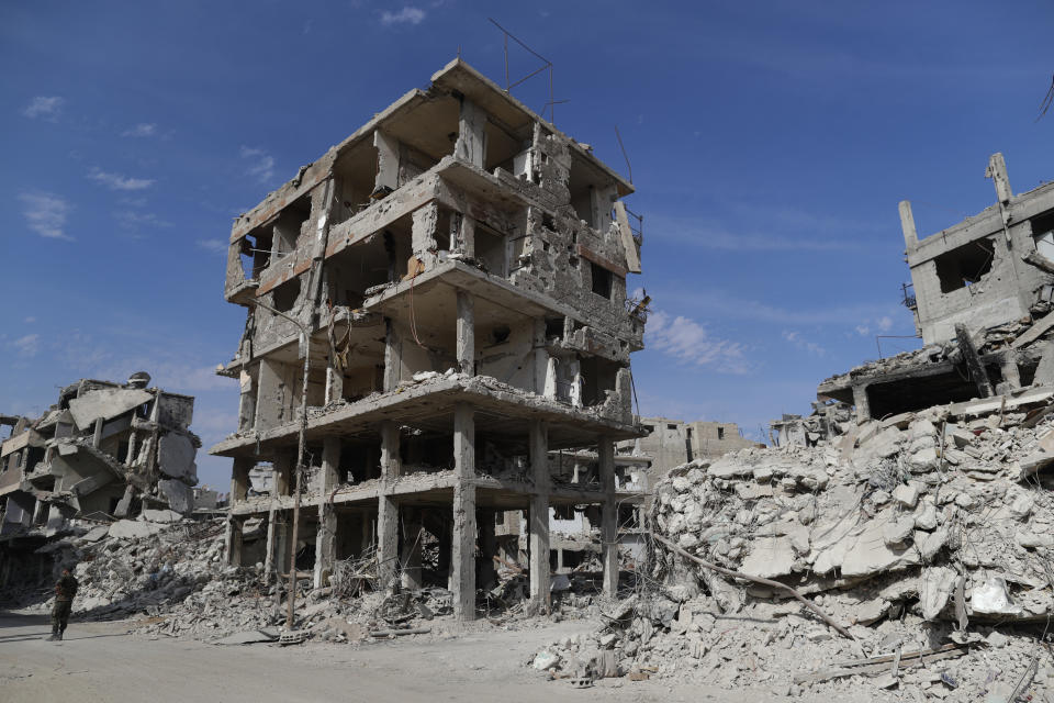 Buildings lie in ruins in the Palestinian refugee camp of Yarmouk in the Syrian capital Damascus, Syria, Saturday, Oct. 6, 2018. Bulldozers and trucks are working to clear tons of rubble from the main streets. The camp, once home to the largest concentration of Palestinians outside the territories housing nearly 160,000 people, has been gutted by years of war. (AP Photo/Hassan Ammar)