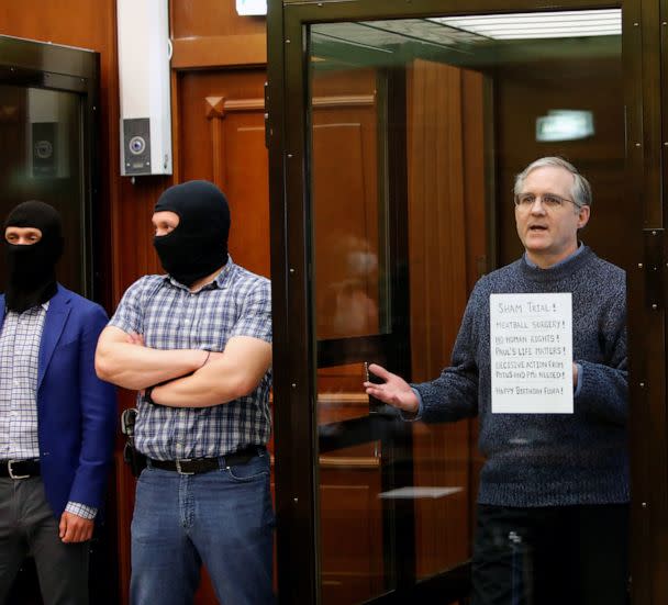 PHOTO: In this June 15, 2020, file photo, former U.S. Marine Paul Whelan, who was detained and accused of espionage, holds a sign as he stands inside a defendants' cage during his verdict hearing in Moscow. (Maxim Shemetov/Reuters, FILE)