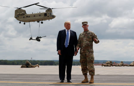 U.S. President Donald Trump talks with U.S. Army Major General Walter “Walt” Piatt, the Commanding General of the Army's 10th Mountain Division and Fort Drum as the president observes a demonstration with U.S. Army 10th Mountain Division troops, artillery and helicopters at Fort Drum, New York, U.S., August 13, 2018. REUTERS/Carlos Barria