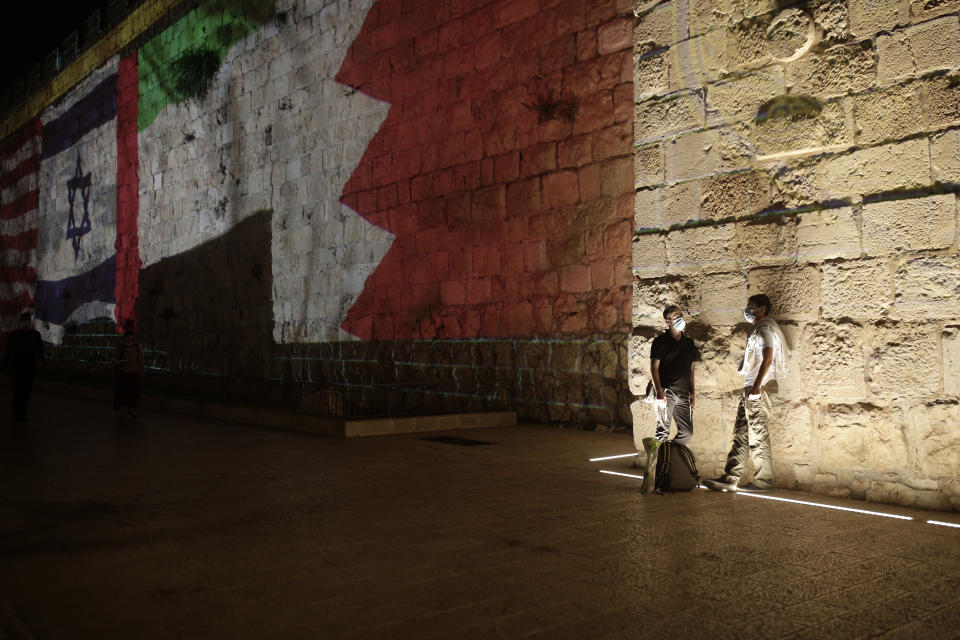 Representations of the Israeli, Emirati and Bahraini flags are projected onto a wall of Jerusalem's Old City, marking the day of a signing ceremony in Washington signifying the two Gulf nations' normalization of relations with Israel, Tuesday, Sept. 15, 2020. (AP Photo/Maya Alleruzzo)