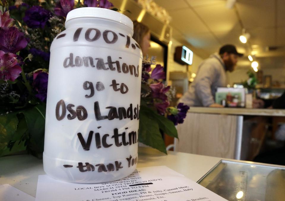 A canister labeled as donations for victims of a deadly landslide sits at the counter of a cafe Friday, March 28, 2014, in Arlington, Wash. The death toll from the mudslide in nearby Oso, Wash., is expected to rise considerably within the next two days as the Snohomish County Medical Examiner's Office catches up with the recovery effort, Snohomish County District 21 Fire Chief Travis Hots said Thursday. (AP Photo/Elaine Thompson)