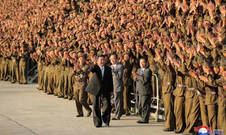 Kim Jong-un walks past hundreds of cheering, waving soldiers.