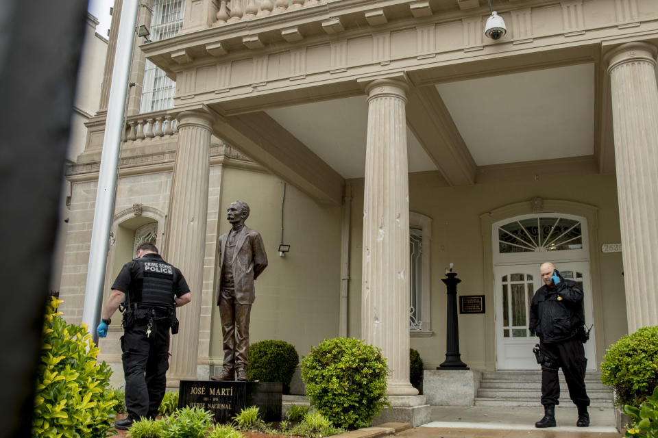 Bullet holes are visible on a column behind a statue of Cuban independence hero José Martí as Secret Service officers investigate after police say a person with an assault rifle opened fire at the Cuban Embassy, Thursday, April 30, 2020, in Washington. Officers found the suspect with an assault rifle and took the person into custody without incident, police said. (AP Photo/Andrew Harnik)